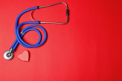 Stethoscope with heart on color background, flat lay