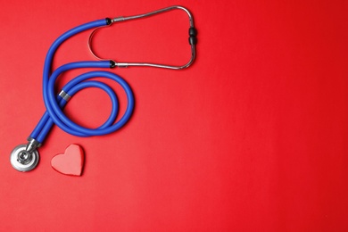 Photo of Stethoscope with heart on color background, flat lay