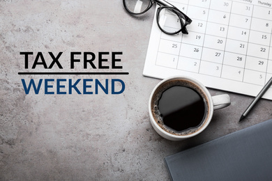 Cup of coffee, stationery and text TAX FREE WEEKEND on grey table, flat lay