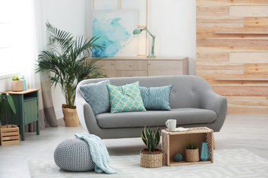 Living room interior with green houseplants and sofa