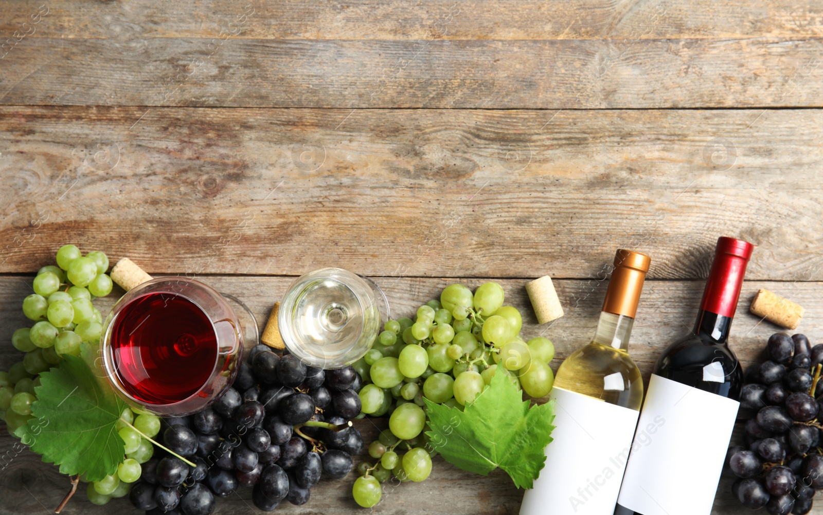 Photo of Flat lay composition with fresh ripe juicy grapes and space for text on wooden background