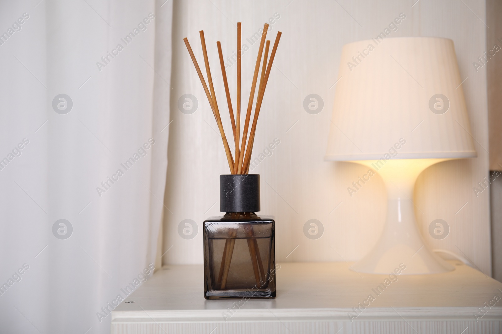 Photo of Aromatic reed freshener on bedside table indoors