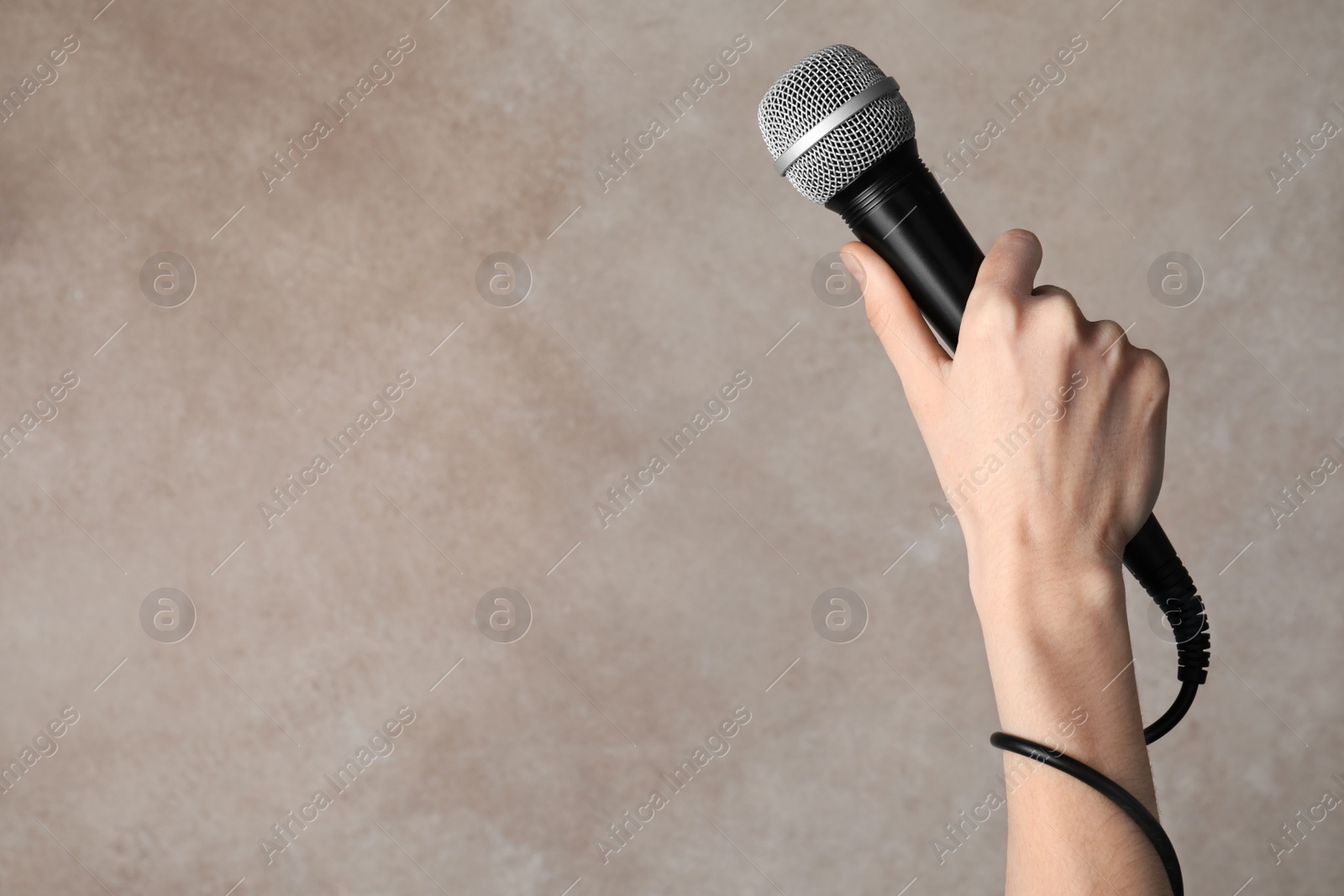 Photo of Woman holding microphone on color background, space for text