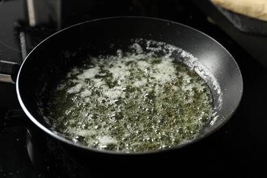 Photo of Melting butter in frying pan on black table, closeup