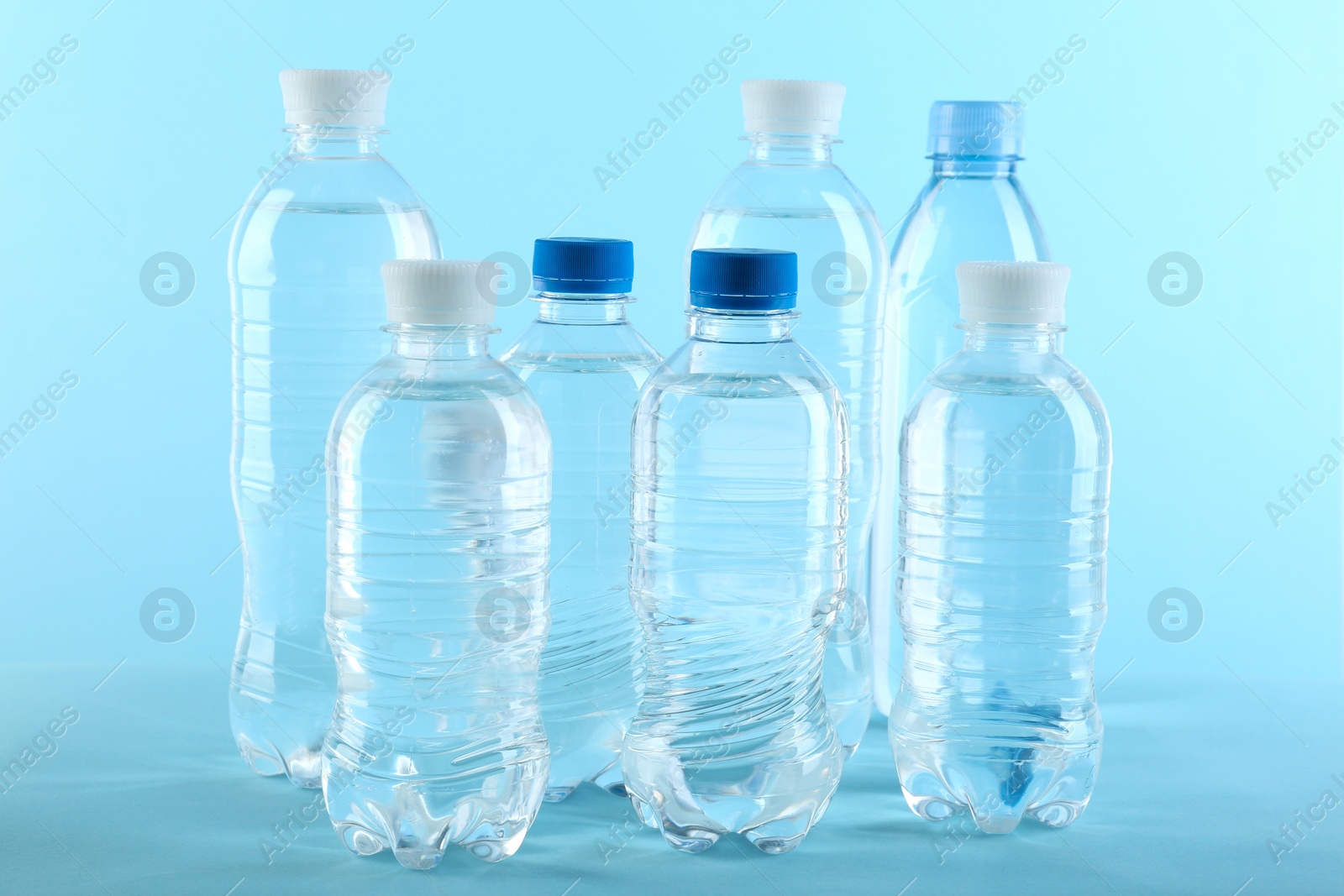 Photo of Set of different plastic bottles with water on blue background