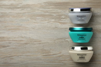Photo of MYKOLAIV, UKRAINE - SEPTEMBER 07, 2021: Kerastase hair care masks on wooden table, flat lay. Space for text