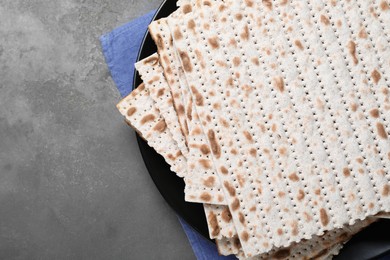 Photo of Stack of traditional matzos on grey table, flat lay