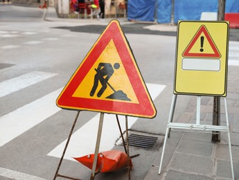 Photo of Different traffic signs near pedestrian crossing on city street