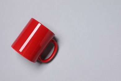 Photo of One red ceramic mug on light background, top view and space for text