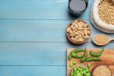 Photo of Different organic soy products on light blue wooden table, flat lay. Space for text