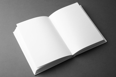 Photo of Open book with blank pages on dark grey background. Mock up for design
