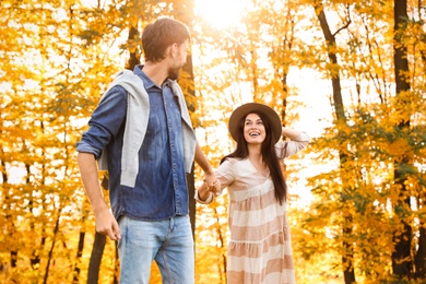 Photo of Happy couple walking in sunny autumn park