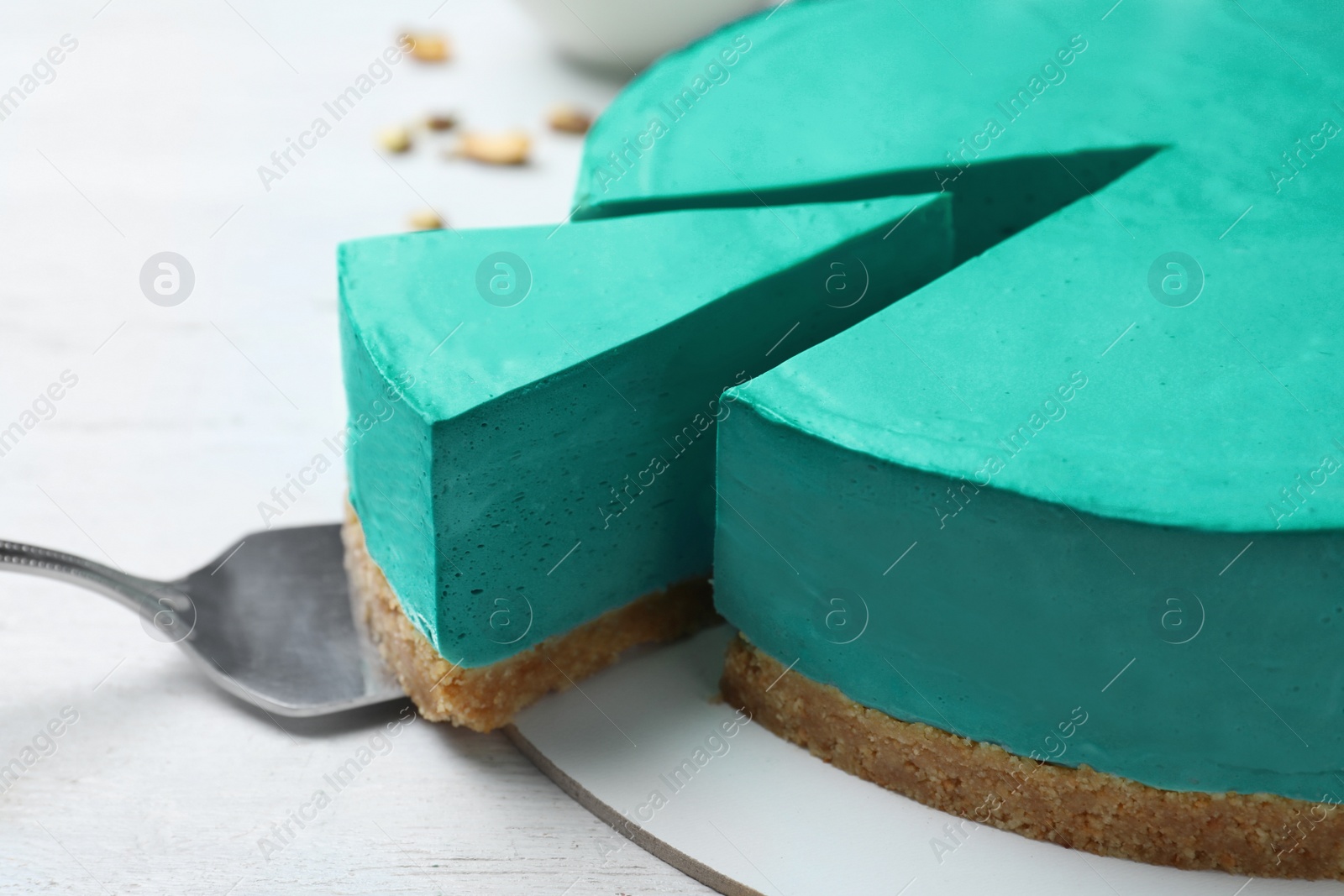 Photo of Delicious homemade spirulina cheesecake on white wooden background