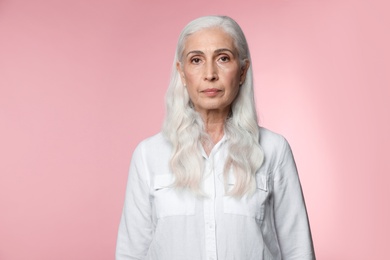 Photo of Portrait of beautiful mature woman on pink background