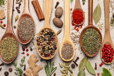 Photo of Different natural spices and herbs on light wooden table, flat lay