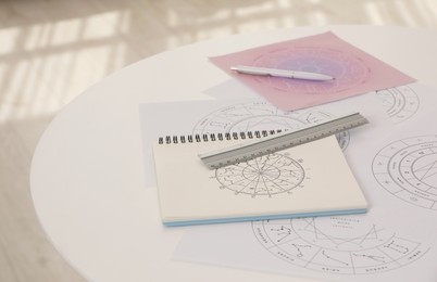 Photo of Zodiac wheels for astrological predictions on white table. Fortune telling