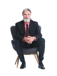 Photo of Handsome bearded mature man in suit sitting in armchair on white background