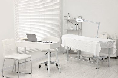 Photo of Modern interior of dermatologist's office with examination table