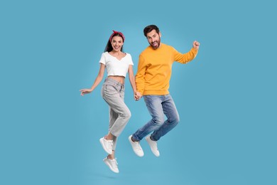 Photo of Happy couple dancing together on light blue background
