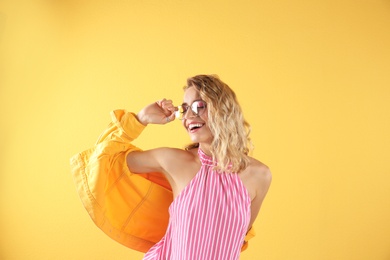 Beautiful young woman posing on color background. Summer fashion