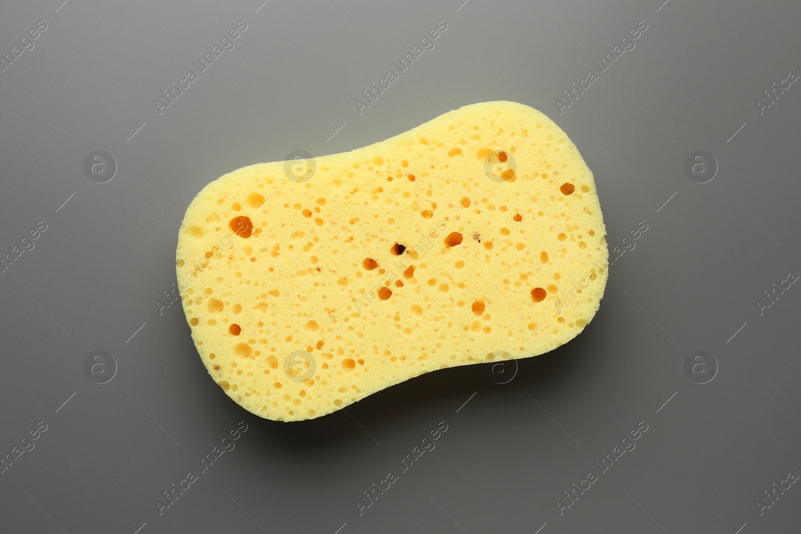 New yellow sponge on grey background, top view Photo of New yellow sponge on grey background, top view