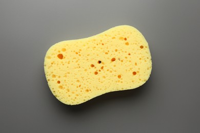 Photo of New yellow sponge on grey background, top view