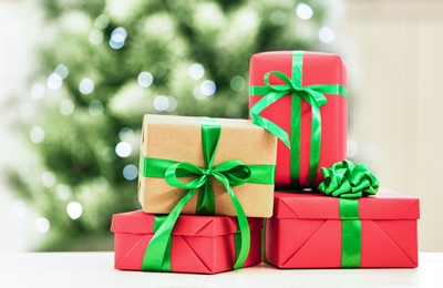 Photo of Christmas gifts on table against blurred background
