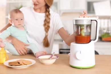 Photo of Woman preparing breakfast for her child in kitchen. Healthy baby food