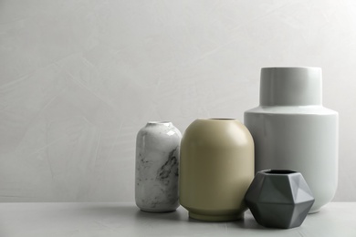 Photo of Stylish ceramic vases on grey stone table. Space for text