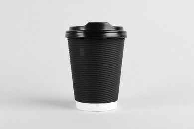 Photo of Black paper cup with plastic lid on light background. Coffee to go