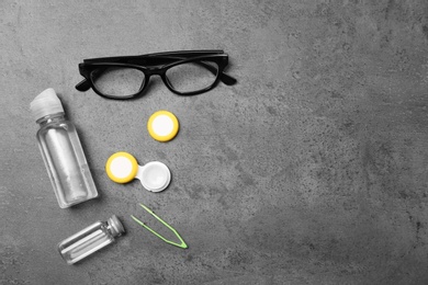 Photo of Glasses and contact lens accessories on grey background, top view