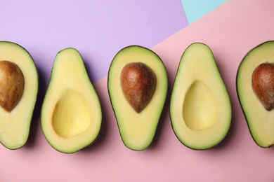 Photo of Cut fresh ripe avocados on color background, flat lay