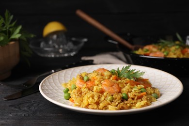 Photo of Tasty rice with shrimps and vegetables on dark wooden table. Space for text