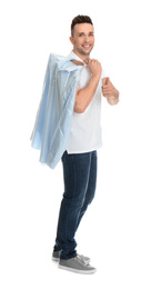 Photo of Man holding hanger with shirt in plastic bag on white background. Dry-cleaning service