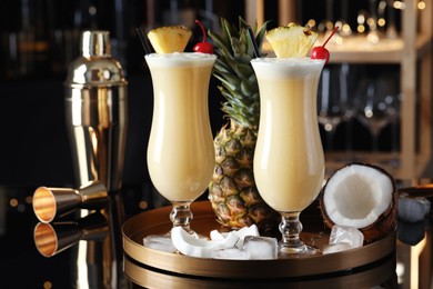 Photo of Tasty Pina Colada cocktails and ingredients on bar countertop