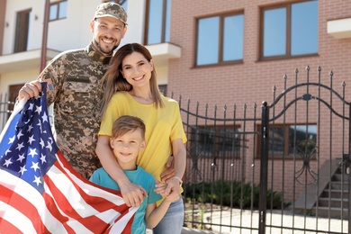 Photo of American soldier reunited with his family outdoors. Military service