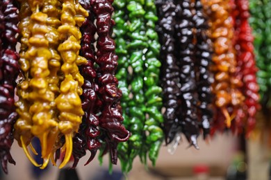 Photo of Bunches of different delicious churchkhelas at market, closeup. Space for text