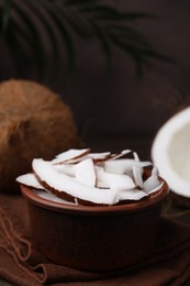Photo of Coconut pieces in bowl and nuts on table