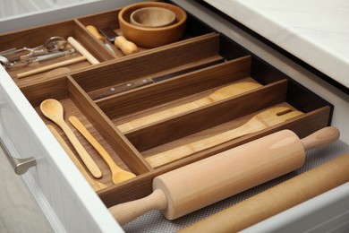 Photo of Open drawer of kitchen cabinet with different utensils, closeup