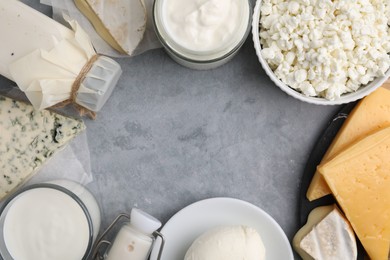 Photo of Frame of different fresh dairy products on grey table, flat lay. Space for text