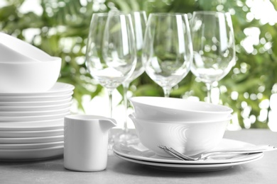 Photo of Set of clean dishes on blurred background