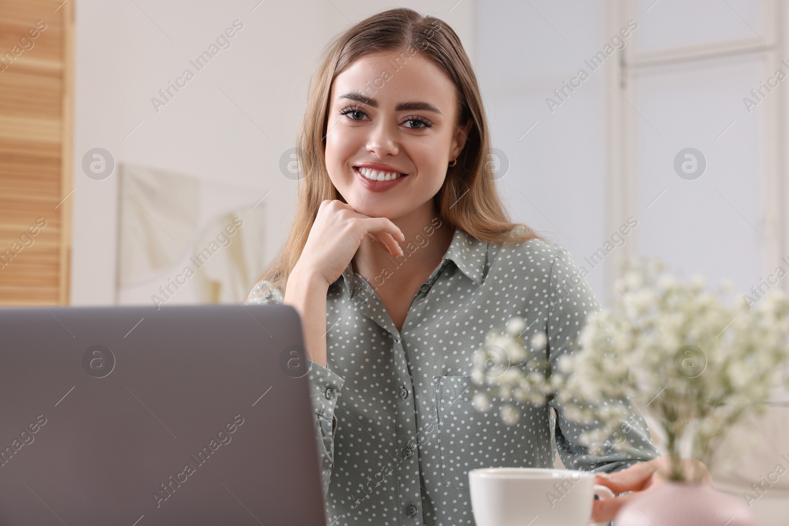 Photo of Happy woman with laptop in living room