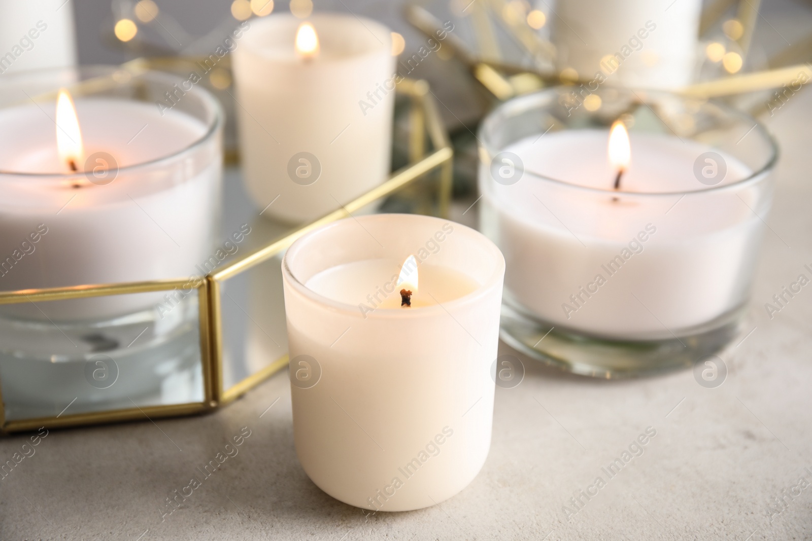 Photo of Burning aromatic candles in holders on table