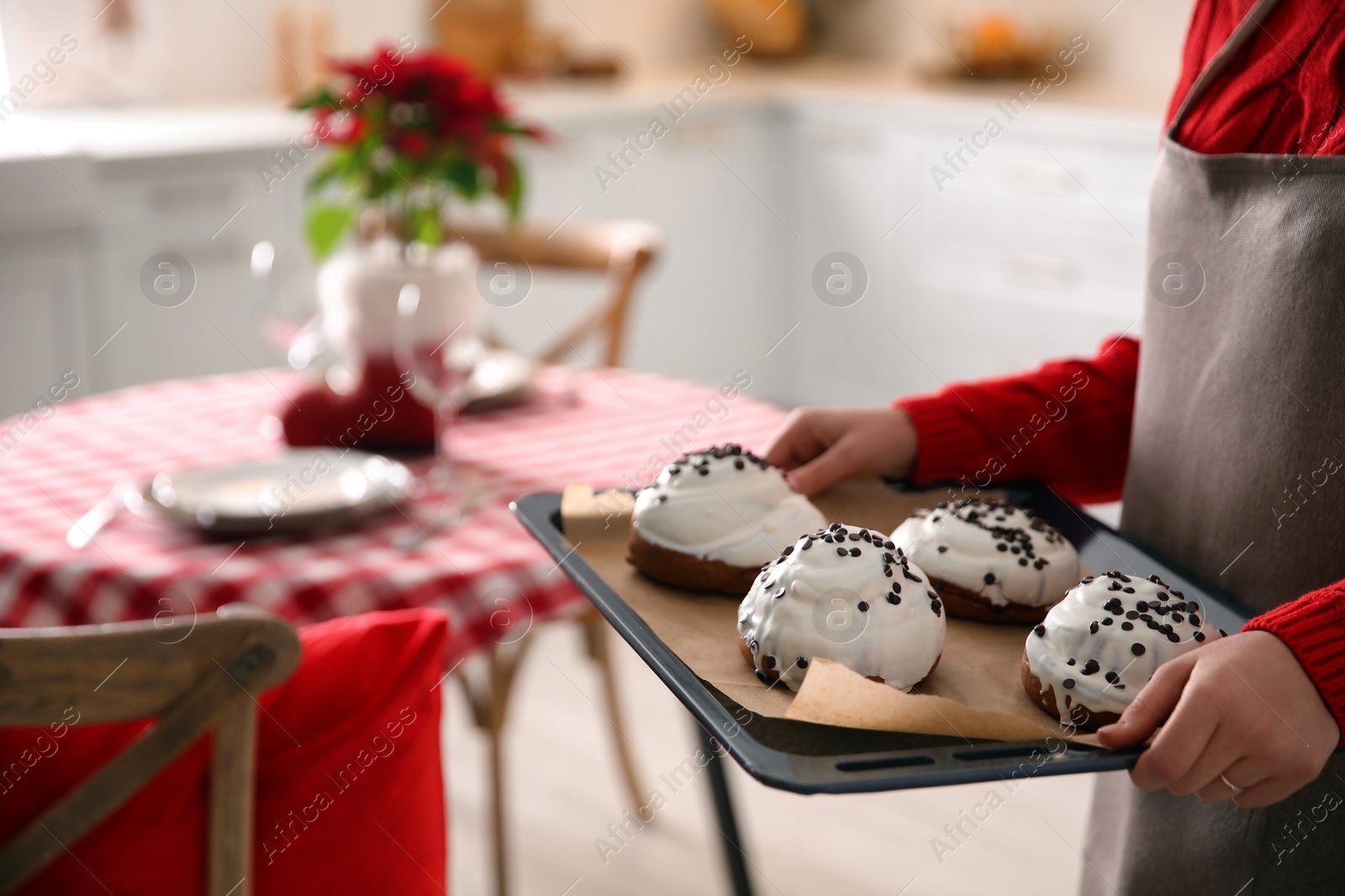 Photo of Woman with sweet buns for Christmas dinner in kitchen, closeup