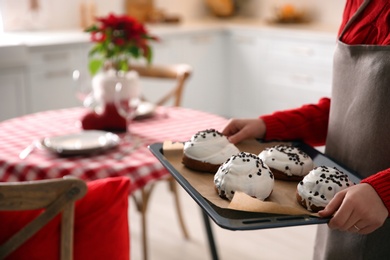 Photo of Woman with sweet buns for Christmas dinner in kitchen, closeup