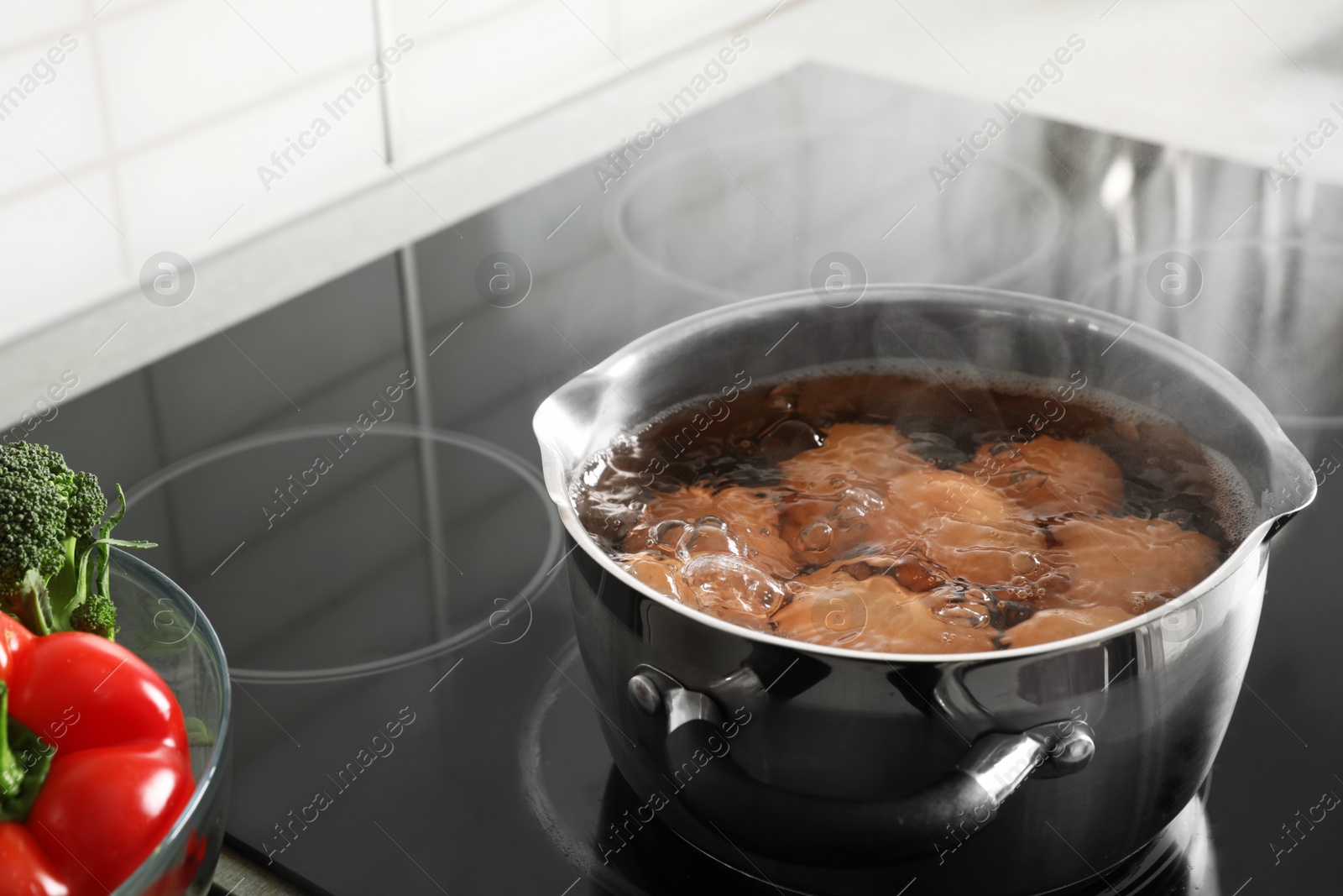 Photo of Cooking chicken eggs in pot on electric stove at kitchen