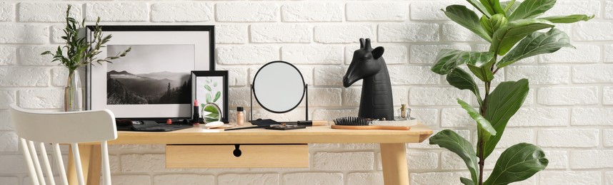 Makeup room. Mirror, cosmetic products and accessories on wooden dressing table indoors, banner design