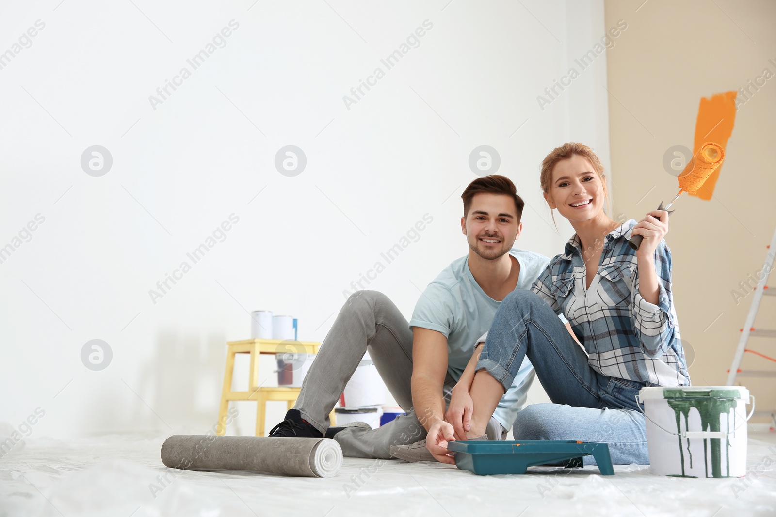 Photo of Happy couple with paint planning home repair indoors