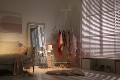 Photo of Modern dressing room interior with clothing rack and mirror