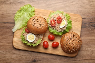 Photo of Delicious sandwiches with tuna, boiled egg and vegetables on wooden table, top view